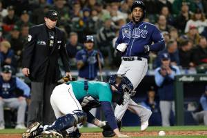 Tampa Bay Rays' Yandy Diaz, right, scores on a Randy Arozarena single as Seattle Mariners catcher Tom Murphy recovers the ball during the second inning of a baseball game Friday, May 6, 2022, in Seattle. (AP Photo/Jason Redmond)