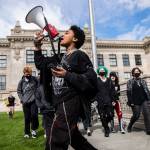 Everett High School student Soren Dellaguardia leads a walkout from the high school to North Middle School on Monday in Everett. (Olivia Vanni / The Herald)
