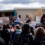 North Middle School students hop over a perimeter fence to join Everett High School students in their walkout on Monday. (Olivia Vanni / The Herald)