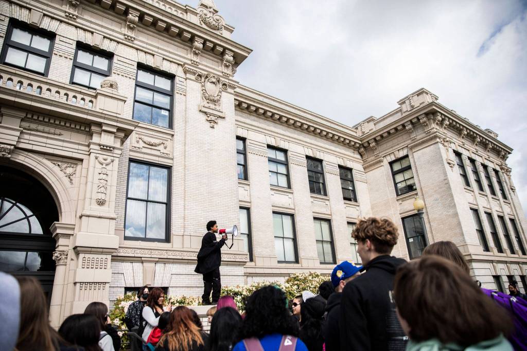Everett High School student Soren Dellaguardia speaks to a group of students before leading a walkout to North Middle School on Monday in Everett. (Olivia Vanni / The Herald)