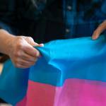 Melissa Batson holds the transgender flag while rifling through the different flags she owns at her home in Monroe. Batson is a transgender woman and flies the flag every Nov. 20  the Transgender Day of Remembrance  to honor transgender people who have lost their lives to transphobic violence. (Ryan Berry / The Herald)