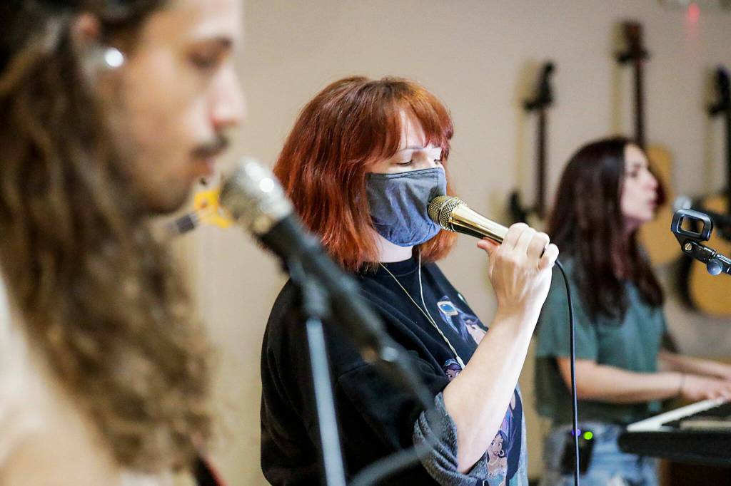 Andrew Vait (left), Annie Jantzer (center) and Linzy Collins (right) of The Little Lies rehearse in Everett on May 16. (Kevin Clark / The Herald)