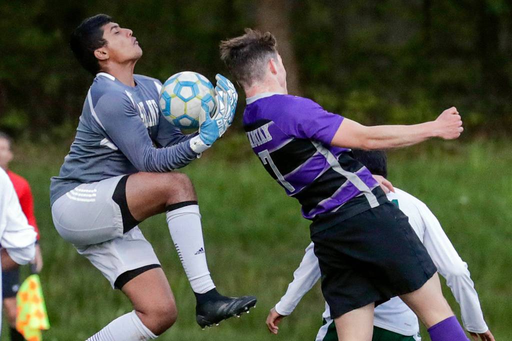 Skylines Arnav Murudkar gather a shot with Kamiaks Koll Pehlivanian attempting a header Tuesday night at Kamiak High School in Mukilteo. (Kevin Clark / The Herald)
