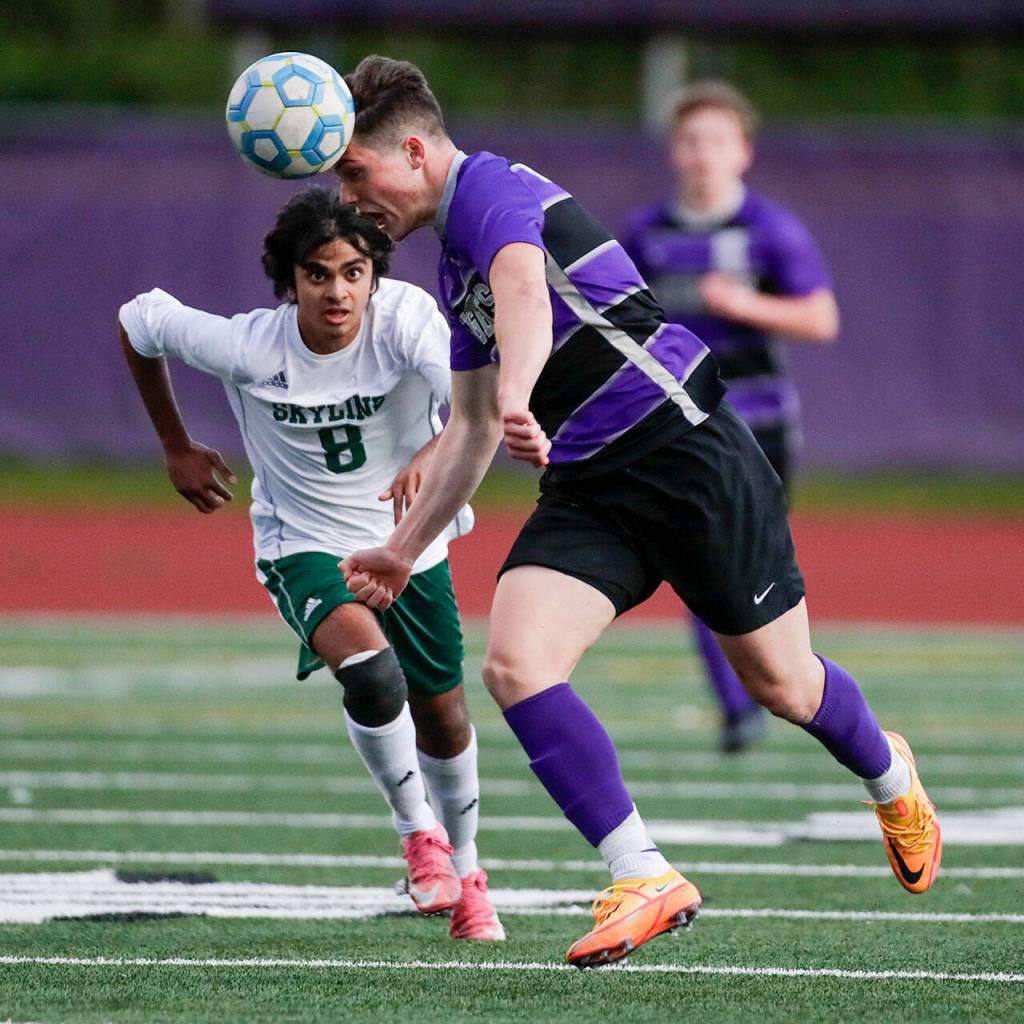 Kamiaks Koll Pehlivanian heads the ball with Skylines Vishnu Varadhan giving chase Tuesday afternoon at Kamiak High School in Mukilteo, Washington on May 10, 2022. (Kevin Clark / The Herald)