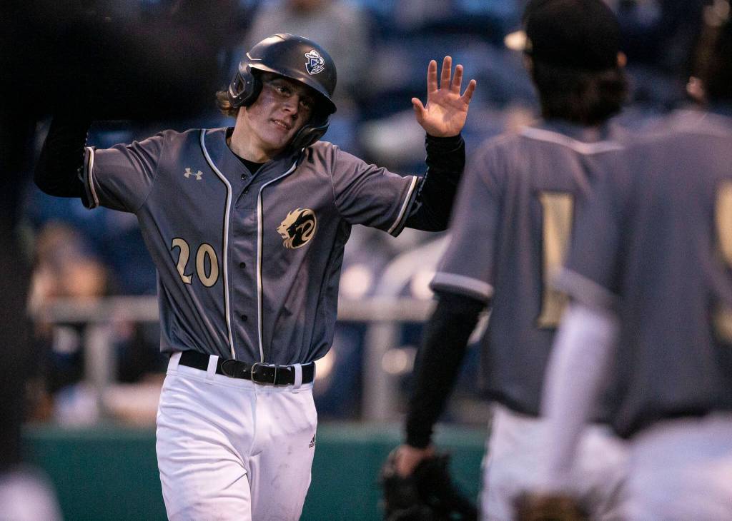 Lynnwoods Mason Lane high fives his teammates after scoring during the district semifinal game at Funko Field on Tuesday in Everett. (Olivia Vanni / The Herald)