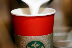 A barista pours steamed milk into a red paper cup while making an espresso drink at a Starbucks coffee shop in the Pike Place Market, Tuesday, Nov. 10, 2015, in Seattle. It's as red as Santa's suit, a poinsettia blossom or a loud Christmas sweater. Yet Starbucks' minimalist new holiday coffee cup has set off complaints that the chain is making war on Christmas. (AP Photo/Elaine Thompson)