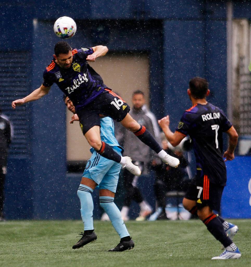 Seattle Sounders Alex Roldán heads away the ball against Minnesota United Sunday at Lumen Field in Seattle. (Ryan Berry / The Herald)