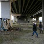 Mandy Jeffcott and Aaron King explore the area beneath a highway underpass while conducting a point-in-time count Feb. 22 in Everett. (Ryan Berry / The Herald)