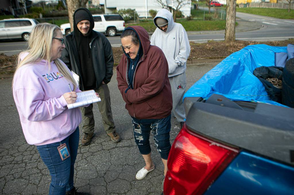 Felicia Rodriguez (center), 49, shares her story with Mandy Jeffcott and Aaron King on Feb. 22 in Everett. Rodriguez had been living in her car since June and said finding help while experiencing homelessness was nearly impossible. (Ryan Berry / The Herald)