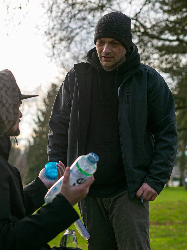 Jonathan Centeno-Echavarria (left) speaks about his experience living in his car to Aaron King, a community resource navigator, Feb. 22 in Everett. Centeno-Echavarria left a bad situation in Seattle and was looking for a more permanent living situation. (Ryan Berry / The Herald)