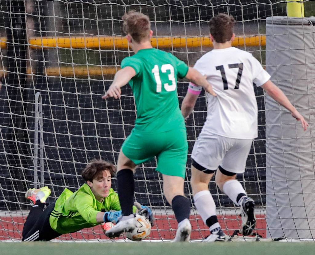 Edmonds-Woodways Gabe Wilhelm jumps on a shot at goal with Edmonds-Woodways Phillip Borchert (center) and Bonney Lakes Connor Goff closing Tuesday at Edmonds-Woodway High School. (Kevin Clark / The Herald)