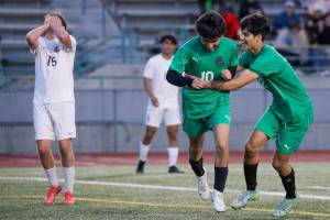 Bonney Lake's James O'Callaghan stands dejected as Edmonds-Woodway's Victor Ibarra, far right, celebrates Edgar Cabrera’s goal in the second half Tuesday evening at Edmonds-Woodway High School in Edmonds, Washington on May 17, 2022. The Warriors won 3-1. (Kevin Clark / The Herald)