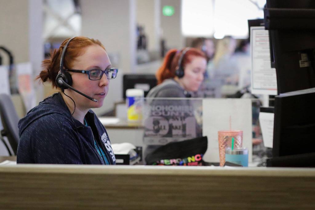 Jessica Carico takes a call Friday afternoon at SNO911 in Everett. (Kevin Clark / The Herald)