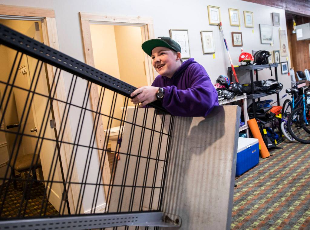 James Nelson, 14, moves a clothing rack at the new Volunteers for America storefront on May 16 in Sultan. (Olivia Vanni / The Herald)