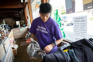Destiny Conner, 13, takes tags off of clothing at the new Volunteers for America storefront on Monday, May 16, 2022 in Sultan, Washington. (Olivia Vanni / The Herald)