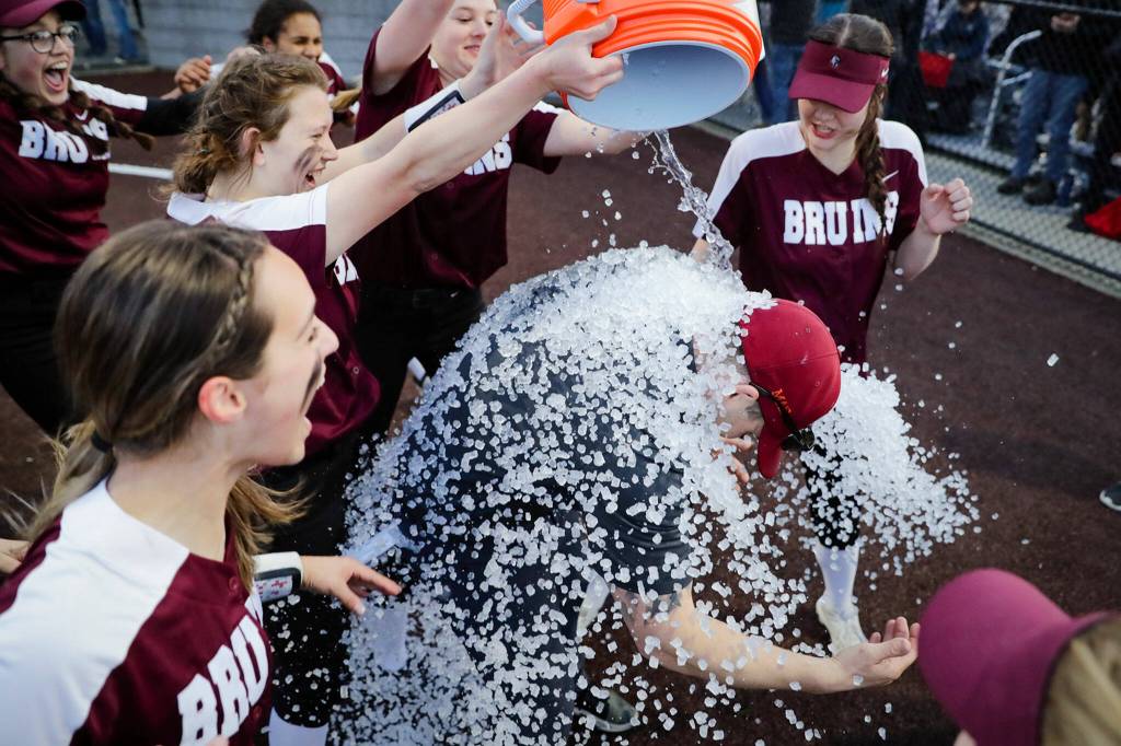 Cascade players dump ice on coach Mike Perrine during their postgame celebration. (Kevin Clark / The Herald)