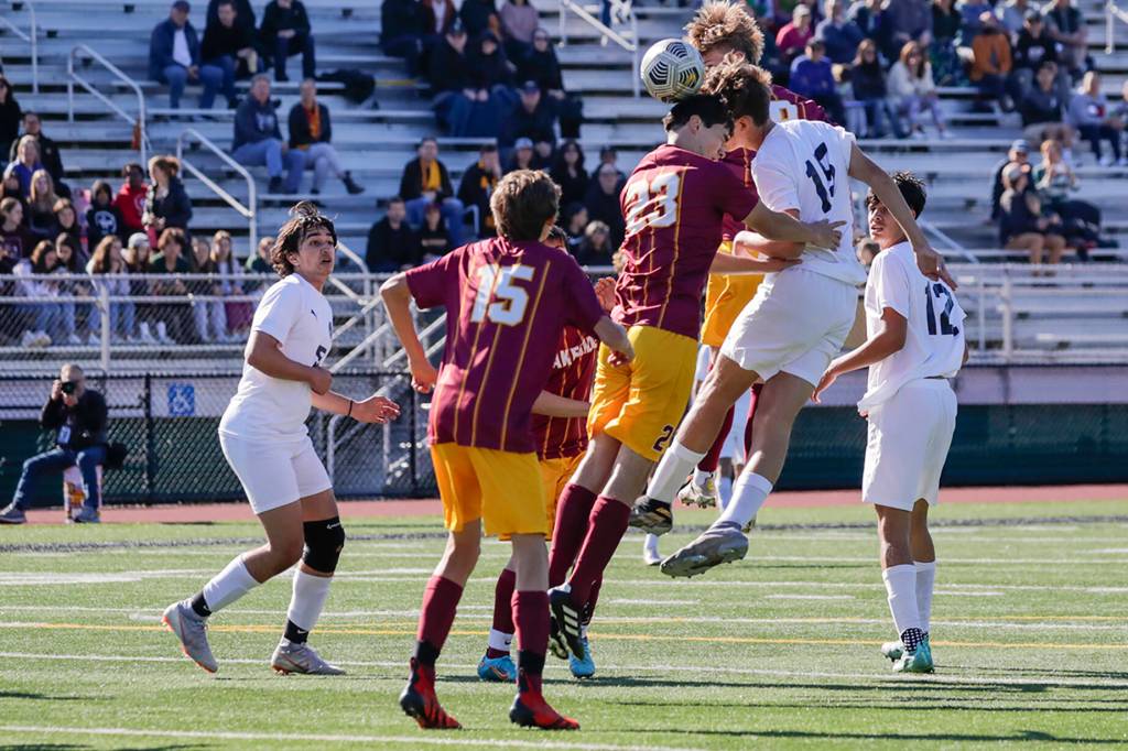 Edmonds-Woodways Deacon Fuentes heads the ball on a corner cook with Lakesides Andrew Streidl defending Friday afternoon in Seattle, Washington on May 20, 2022. The Warriors lost 4-0. (Kevin Clark / The Herald)