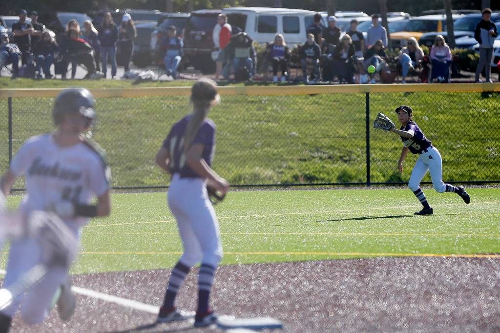 Lake Stevens Emily Cardenas fields the ball on the hop as a Jackson runner scores during a 4A bi-district matchup Friday at the Phil Johnson Ballfields in Everett. (Ryan Berry / The Herald)