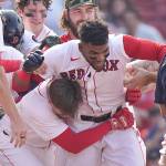 Boston Red Soxs Franchy Cordero, center, celebrates with teammates after hitting a grand slam in the tenth inning of a game against the Seattle Mariners on Sunday in Boston. The Red Sox won 8-4. (AP Photo/Steven Senne)
