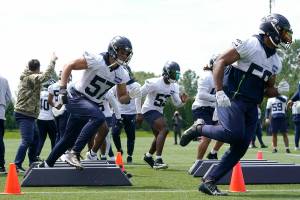 Seattle Seahawks linebackers Cody Barton (57) and Jordan Brooks, right, run a drill during NFL football practice Monday, May 23, 2022, in Renton, Wash. (AP Photo/Ted S. Warren)