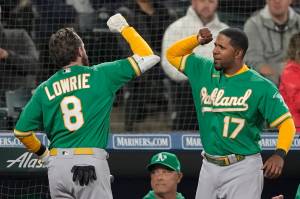Oakland Athletics Jed Lowrie (8) is greeted at the dugout by Elvis Andrus (17) after Lowrie hit a two-run home run during the fifth inning of a game against the Seattle Mariners on Tuesday in Seattle. (AP Photo/Ted S. Warren)
