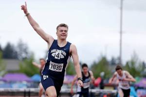 Arlington’s Parker Duskin throws up a hand after defeating the competition in the 3A boys 300 hurdles Saturday, May 28, 2022, at the 2022 WIAA State Track & Field Championships at Mount Tahoma High School in Tacoma, Washington. (Ryan Berry / The Herald)