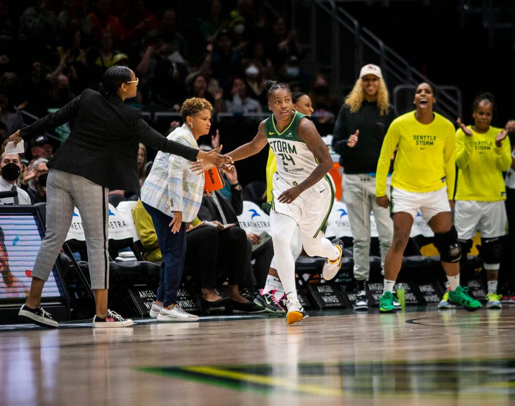 Seattle Storms Jewell Loyd high-fives head coach Noelle Quinn while the Storm bench reacts to her three-point shot during the game against the Liberty on Sunday, May 29, 2022 in Seattle, Washington. (Olivia Vanni / The Herald)