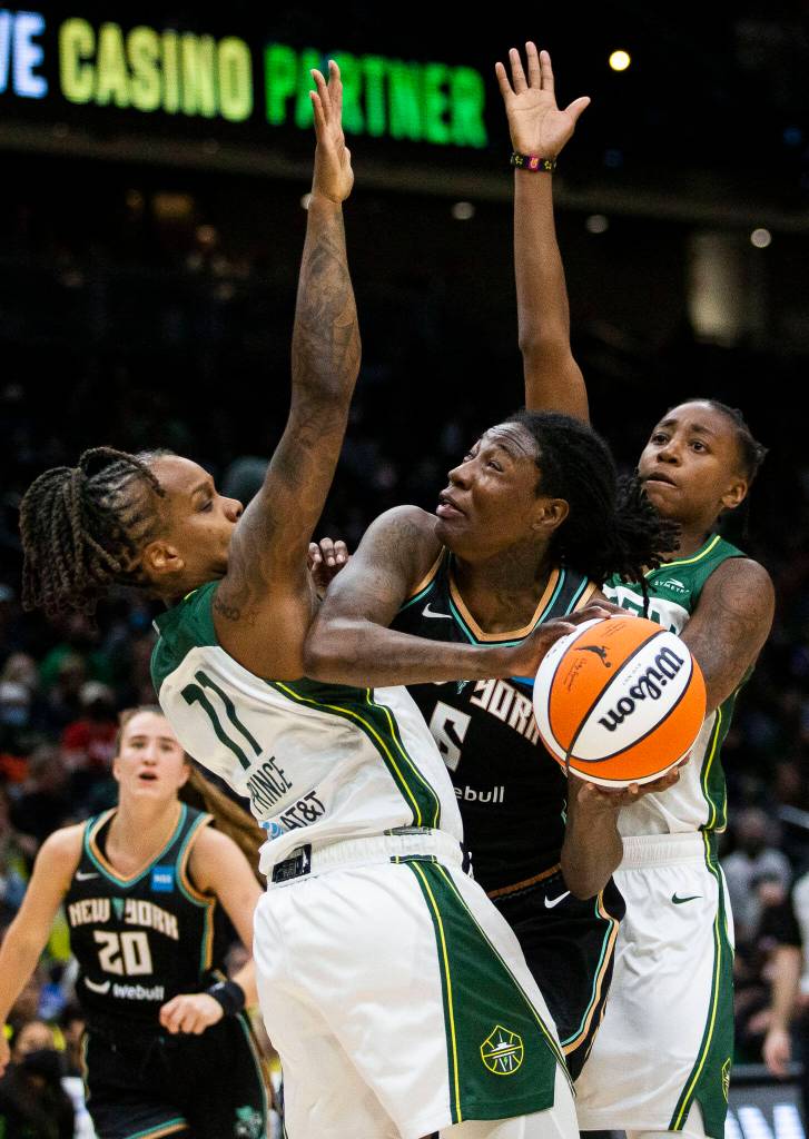 Seattle Storms Epiphanny Prince and Jewell Loyd double team New York Libertys Natasha Howard during the game on Sunday, May 29, 2022 in Seattle, Washington. (Olivia Vanni / The Herald)
