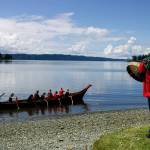 A canoe leaves the shore of Tulalip Bay after the 2022 Salmon Ceremony. (Isabela Breda / The Herald)