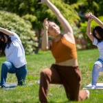 Two girls follow the lead of Iza Narag (center) during a yoga session at Leadership Launchs Emotion Commotion event at Everett Community College in Everett. (Ryan Berry / The Herald)