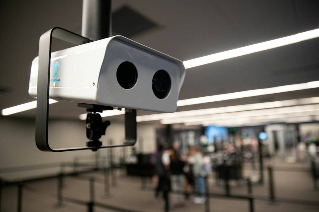 An Athena thermometer hangs overhead at the entrance to the TSA line Friday, May 27, 2022, at Paine Field in Everett, Washington. The device measures the temperature of passengers getting in line and alerts authorities if anybody is running a fever. (Ryan Berry / The Herald)
