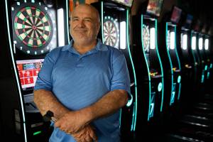 Flint Ferguson, Bernadette “Bernie” Johnson’s partner, stands next to the dart boards inside the Clubhouse Bar and Grill in Everett where Bernie would play darts regularly. (Olivia Vanni / The Herald)
