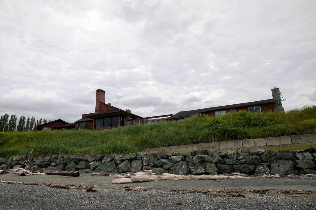 A beach house, bulkhead wall and riprap, seen on June 10, will all have to be removed to return the beachfront to a more natural state at the site of the Keystone Preserve near Coupeville. (Ryan Berry / The Herald)