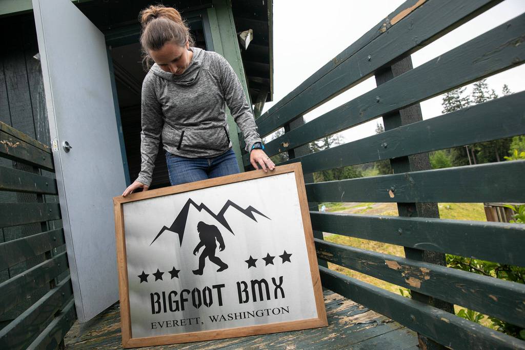 Marlena Berkheiser, track operator and president of Bigfoot BMX, shows off a handmade sign the group uses during racing events. (Ryan Berry / The Herald)