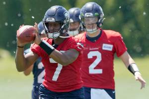 Seattle Seahawks quarterbacks Drew Lock (2) and Geno Smith (7) take part in a drill during NFL football practice, Tuesday, May 31, 2022, in Renton, Wash. (AP Photo/Ted S. Warren)
