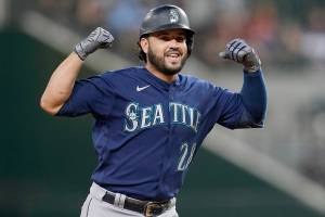 Seattle Mariners' Eugenio Suarez gestures to the dugout as he rounds the bases after hitting a two-run home run against the Texas Rangers in the ninth inning of a baseball game, Friday, June 3, 2022, in Arlington, Texas. (AP Photo/Tony Gutierrez)
