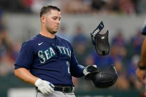 Seattle Mariners' Ty France tosses his gear after a line-out during the third inning of a baseball game against the Texas Rangers in Arlington, Texas, Saturday, June 4, 2022. (AP Photo/LM Otero)
