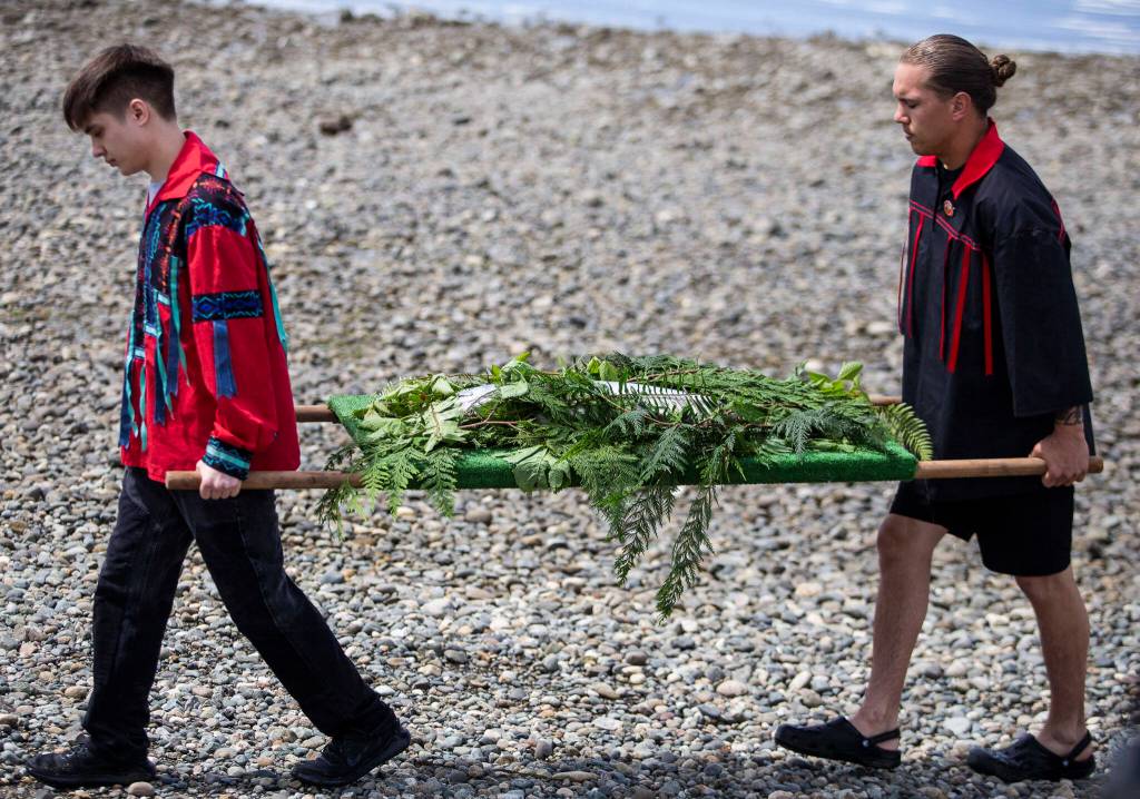 A king salmon is carried to the longhouse for the Salmon Ceremony on Saturday in Tulalip. (Olivia Vanni / The Herald)