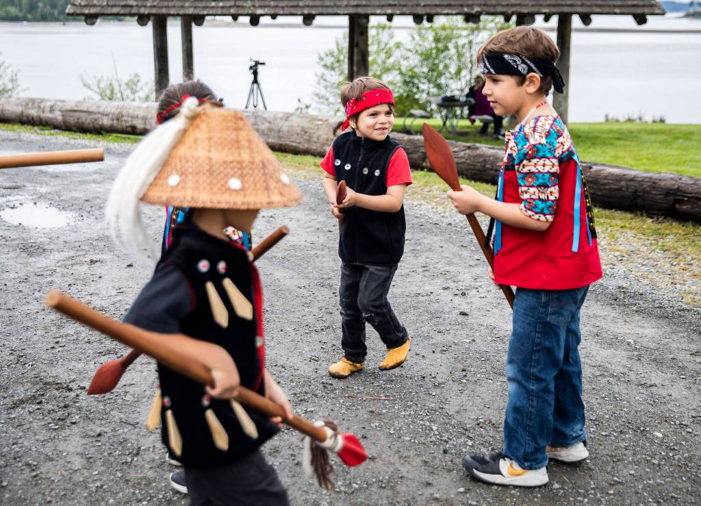 Children dressed as warriors for the Salmon Ceremony play outside the longhouse before heading inside on Saturday in Tulalip. (Olivia Vanni / The Herald)