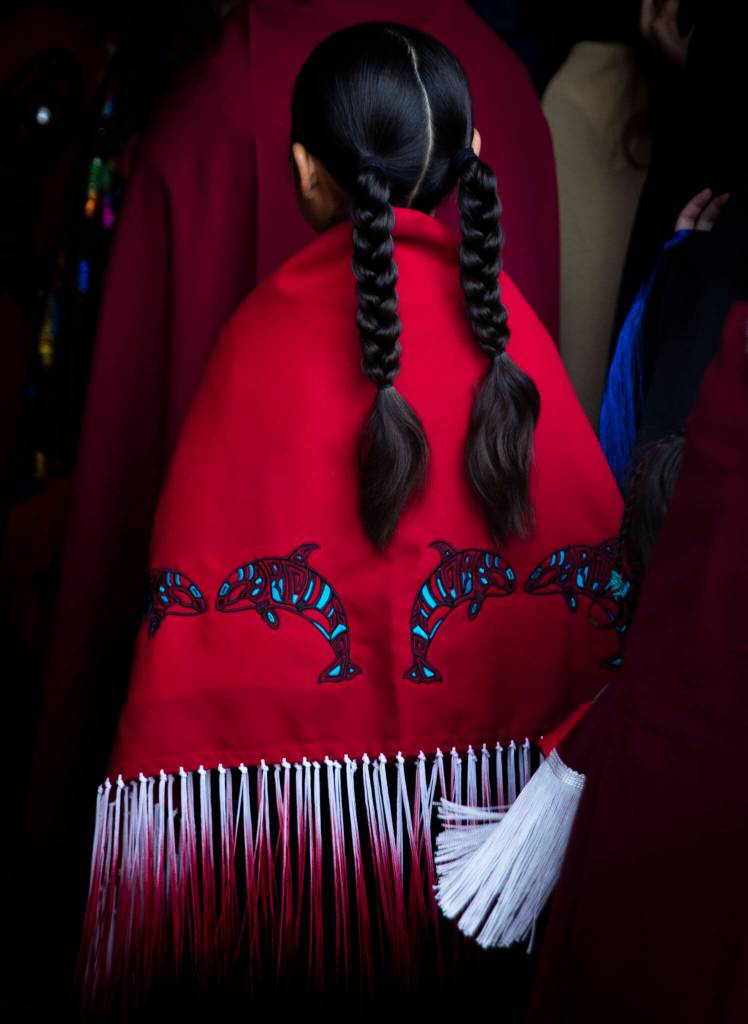 A young girl walks into the longhouse for the Salmon Ceremony on Saturday in Tulalip. (Olivia Vanni / The Herald)