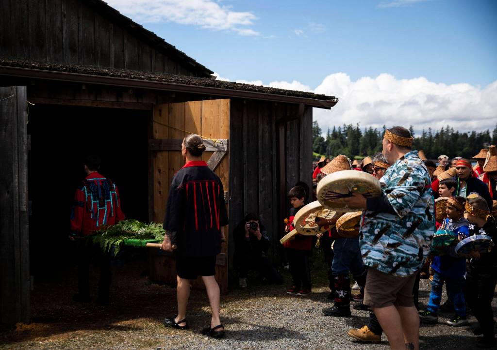 A salmon is carried into the longhouse for the Salmon Ceremony on Saturday in Tulalip. (Olivia Vanni / The Herald)
