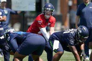 Seattle Seahawks quarterback Drew Lock (2) takes a snap from center Kyle Fuller during NFL football practice, Tuesday, May 31, 2022, in Renton, Wash. (AP Photo/Ted S. Warren)