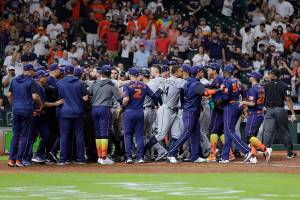 Both dugouts empty and umpires try to keep order after Seattle Mariners batter Ty France was hit by a pitch from Houston Astros relief pitcher Hector Neris during the ninth inning of a baseball game Monday, June 6, 2022, in Houston. (AP Photo/Michael Wyke)