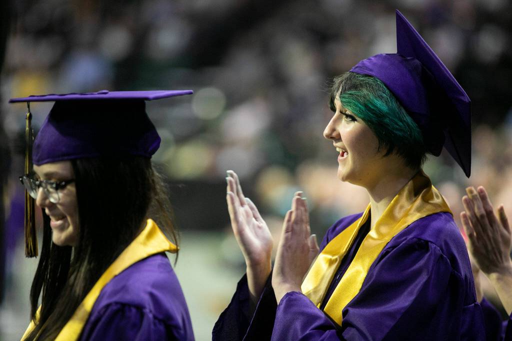 Students clap for classmates as they await their turn onstage during Lake Stevens High Schools 2022 commencement ceremony Tuesday at Angel of the Winds Arena in Everett. (Ryan Berry / The Herald)