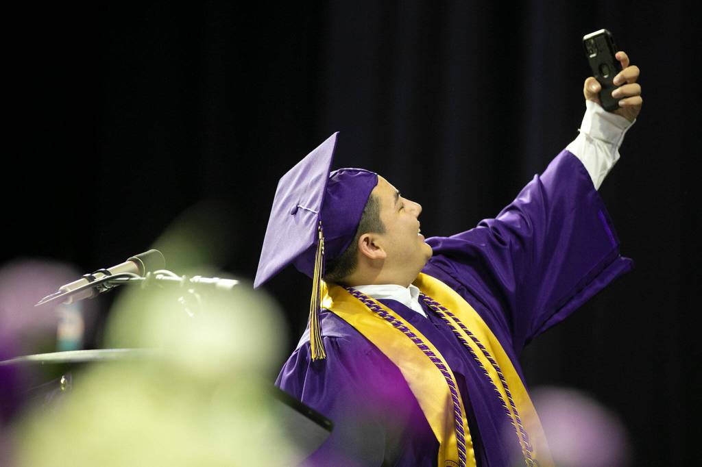 Student body President Kamden Ith captures one last group image during his speech at Lake Stevens High Schools 2022 commencement ceremony Tuesday at Angel of the Winds Arena in Everett. (Ryan Berry / The Herald)