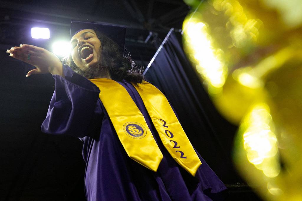 A graduate blows kisses from the stage before receiving her diploma during Lake Stevens High Schools 2022 commencement ceremony Tuesday at Angel of the Winds Arena in Everett. (Ryan Berry / The Herald)