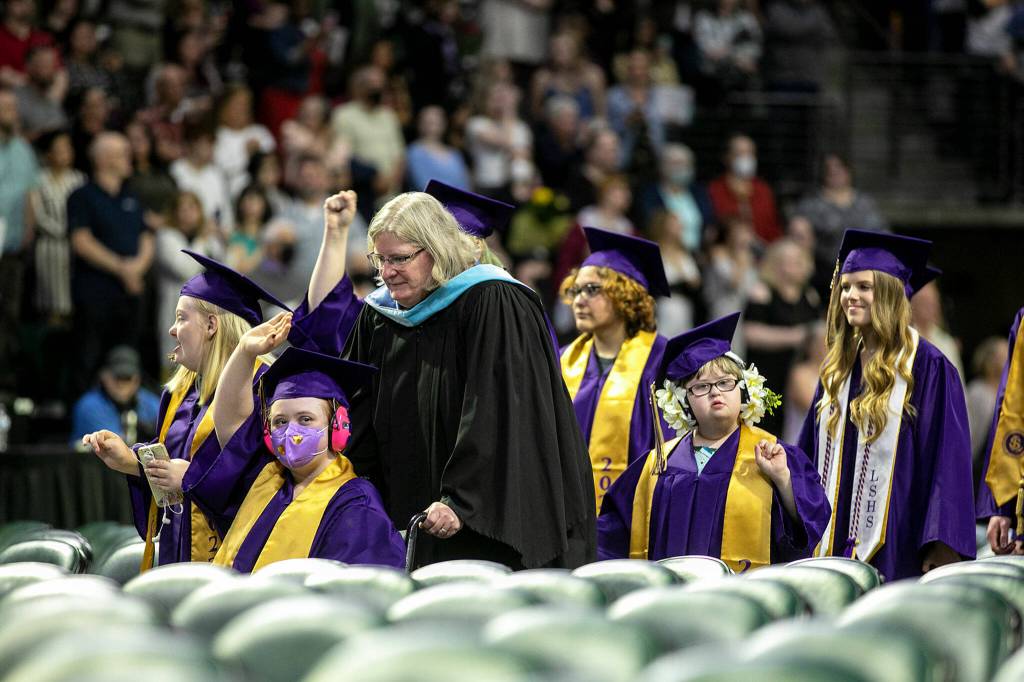 Students proceed down the center aisle at the beginning of Lake Stevens High Schools 2022 commencement ceremony Tuesday at Angel of the Winds Arena in Everett. (Ryan Berry / The Herald)