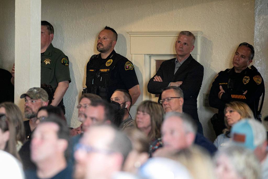 Members of local law enforcement, including Marysville Chief of Police Erik Scairpon, watch during a public safety town hall meeting Wednesday at the Marysville Opera House in Marysville. (Ryan Berry / The Herald)