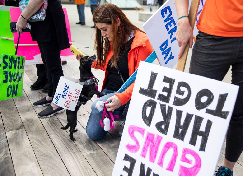Shannon Smith takes a photo of her dog during the March for Our Lives rally at the Snohomish County Courthouse Plaza on Saturday in Everett. (Olivia Vanni / The Herald)
