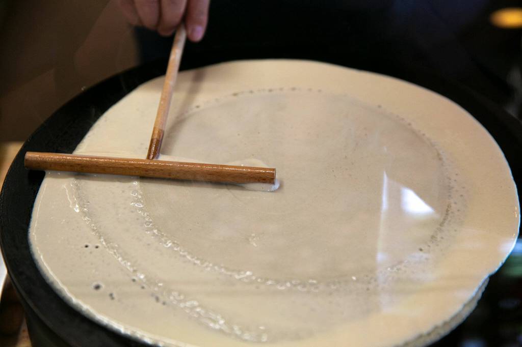 Teresa Godfrey uses a crepe spreader to prepare a dish at Cup & Crêpe on Everett Mall Way in Everett. (Ryan Berry / The Herald)